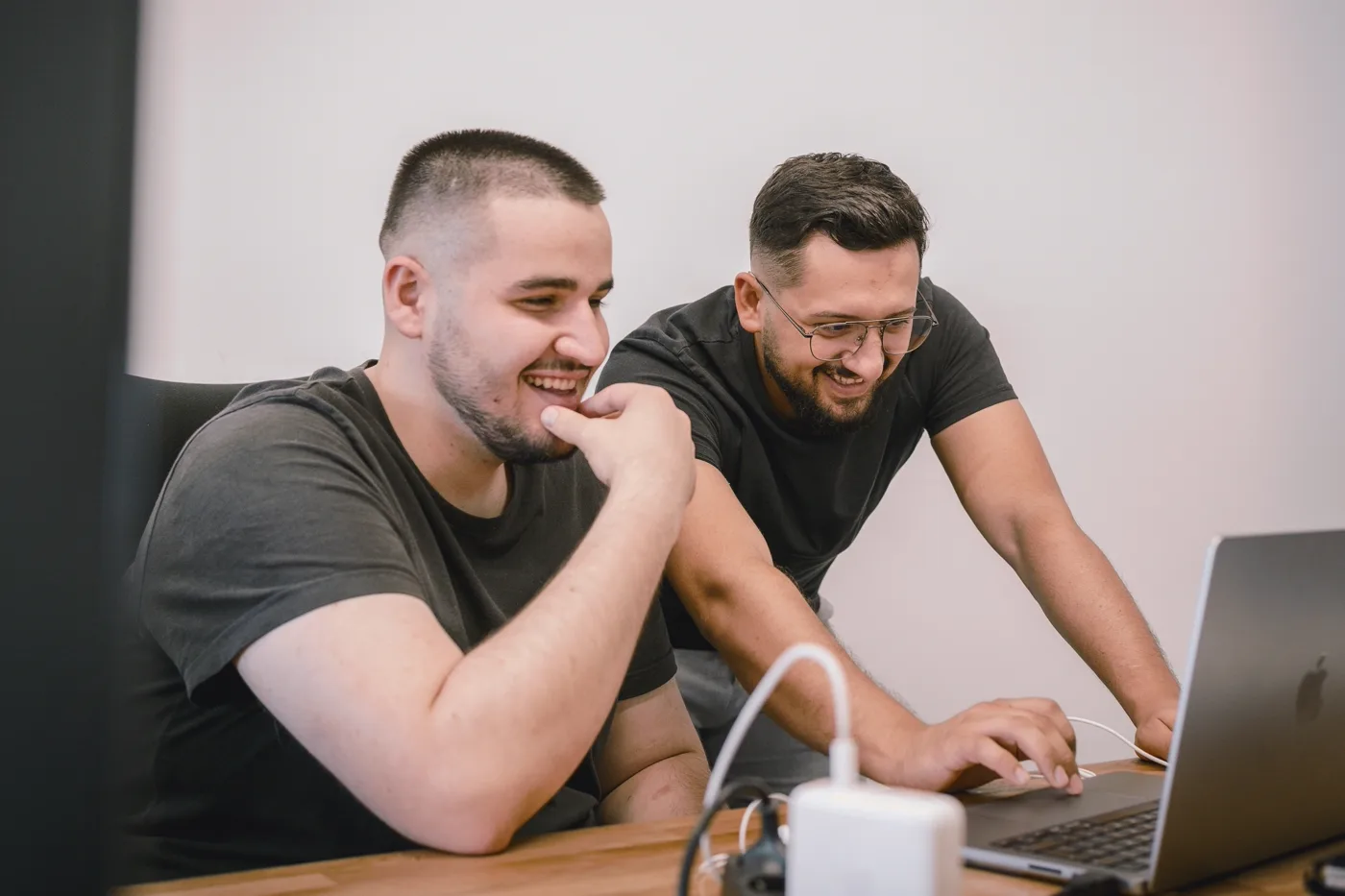 Two developers pair programming on custom software at a bright office table